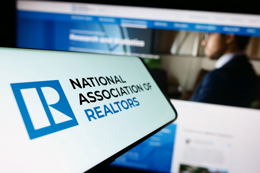 Smartphone with logo of American National Association of Realtors (NAR) on screen in front of website. Focus on center-left of phone display. Unmodified photo.